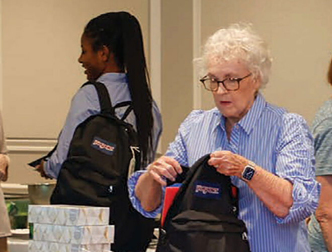 Moorings Park resident filling a backpack with school supplies