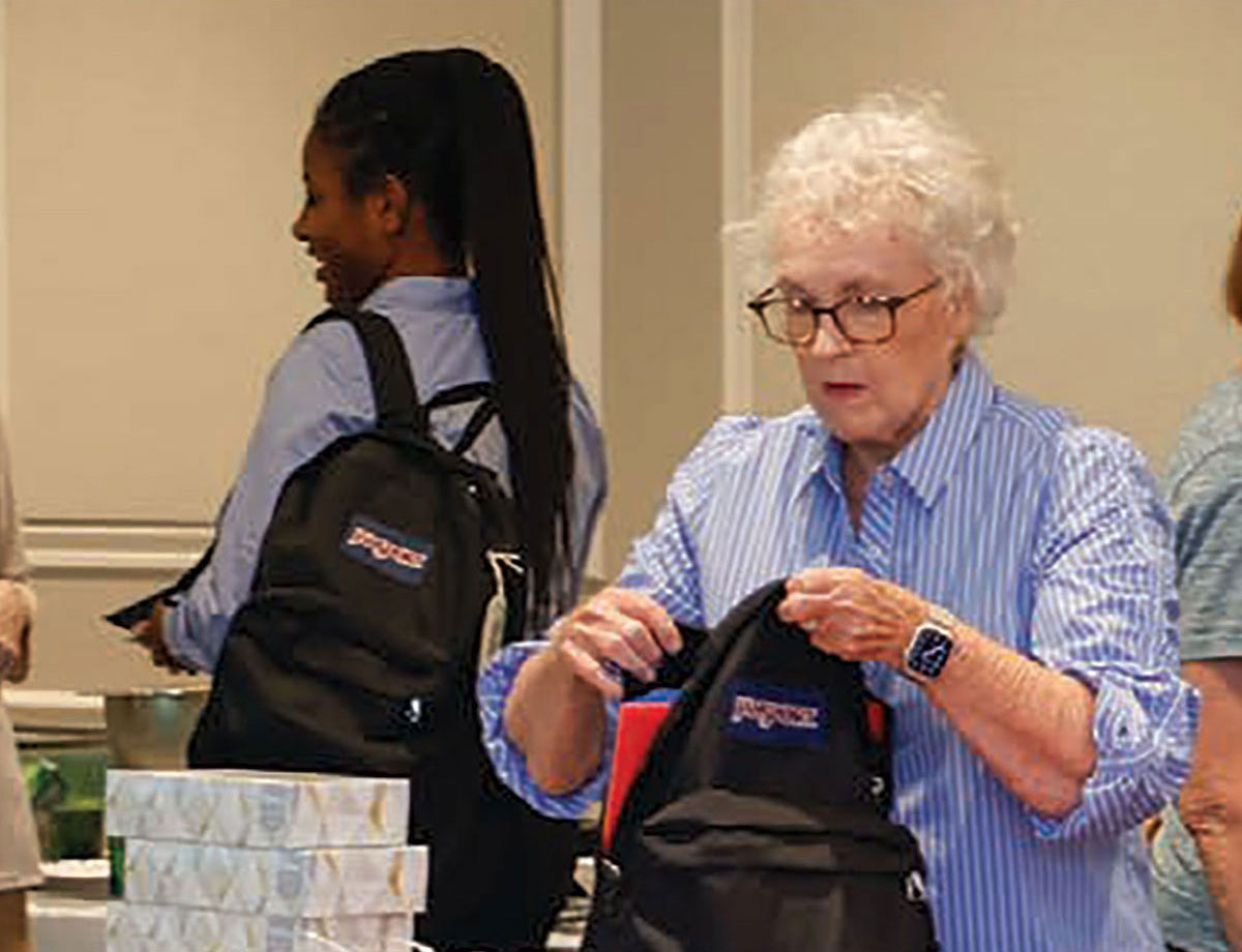 Moorings Park resident filling a backpack with school supplies