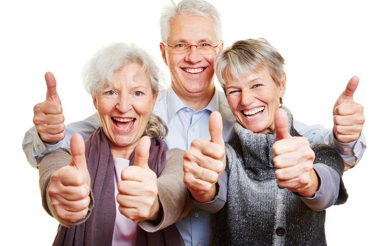 Three happy people giving the thumbs up with both hands