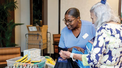 Moorings Park resident helping a woman select school supplies